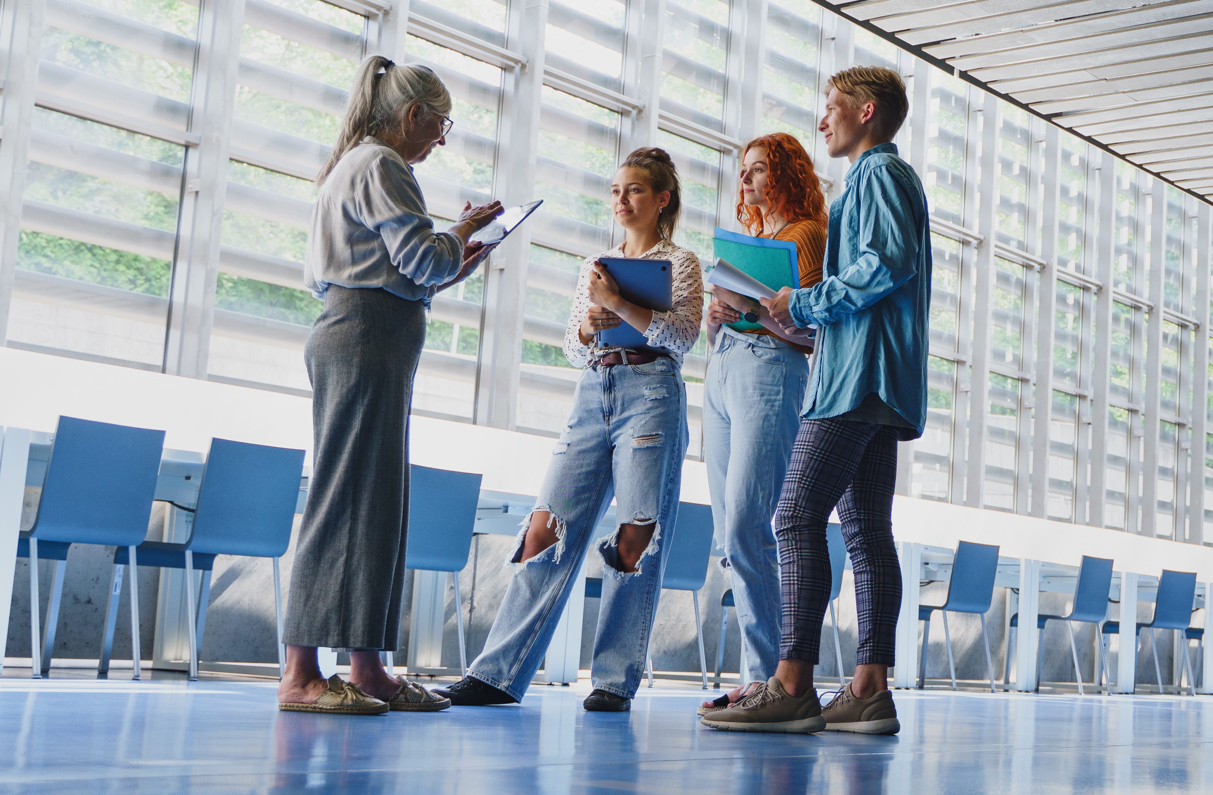 four people standing and holding clipboards
