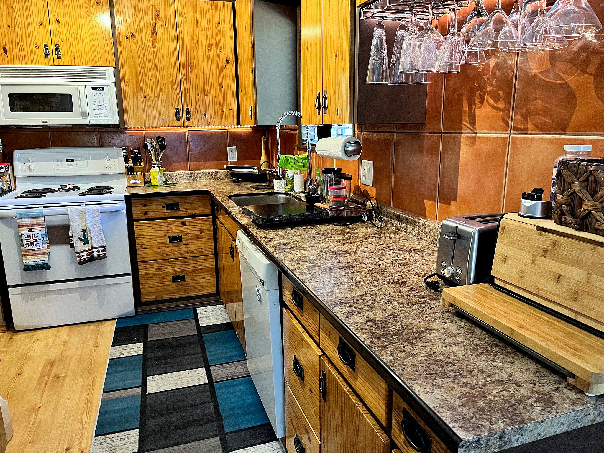 Kitchen space with wood cabinets, white appliances