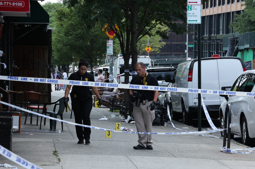 NYPD Crime Scene Unit detectives investigate the Brooklyn mass shooting outside Taste of the City Lounge.