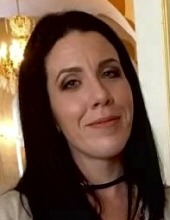 Stefanie Caraway, a woman with long dark hair, looks into the camera.