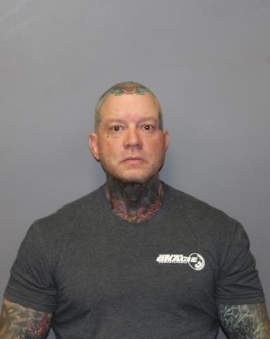 Mugshot of Shawn Lichtfuss, a bald man with tattoos on his head, neck, and arms, wearing a grey t-shirt.
