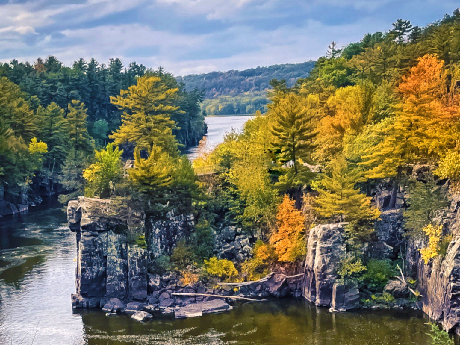 Trees changing color on the bank of a river.