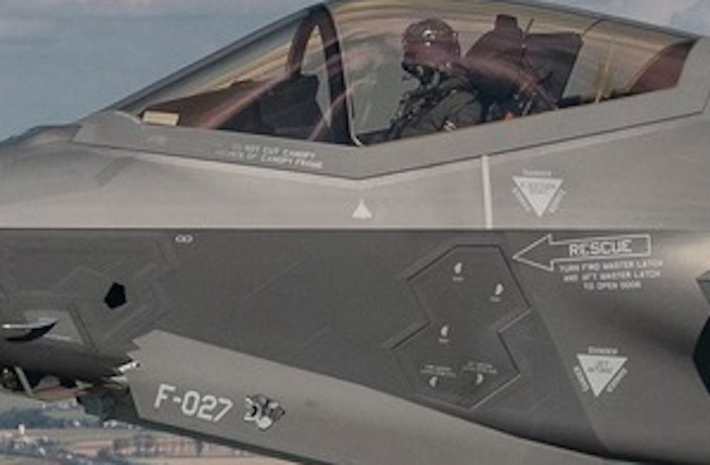 the side of a grey aircraft with a white drone-shaped mark