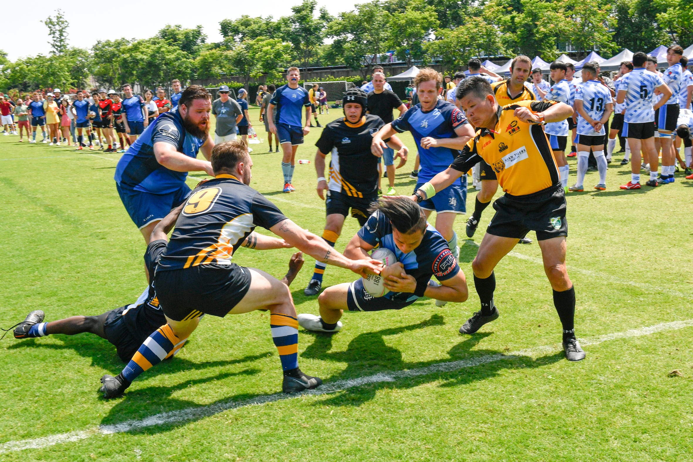 Christopher Zhang scoring a try on a rugby field.