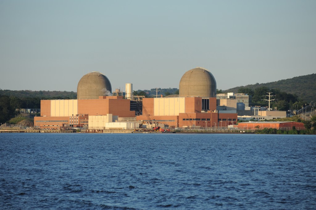 Indian Point Nuclear Power Plant with two large, dome-shaped reactors next to the water.
