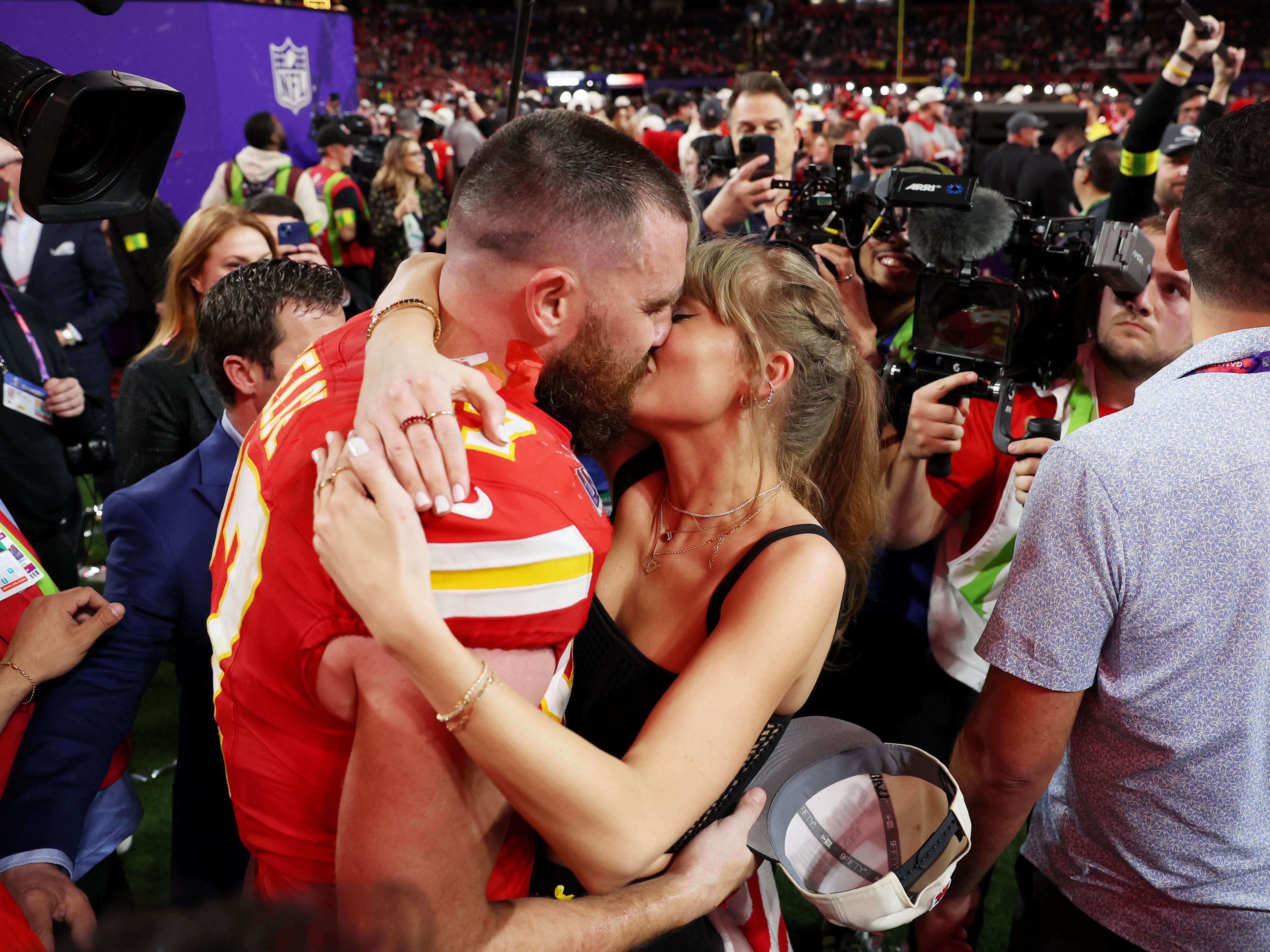 Travis Kelce and Taylor Swift celebrating on the field after Super Bowl LVIII.