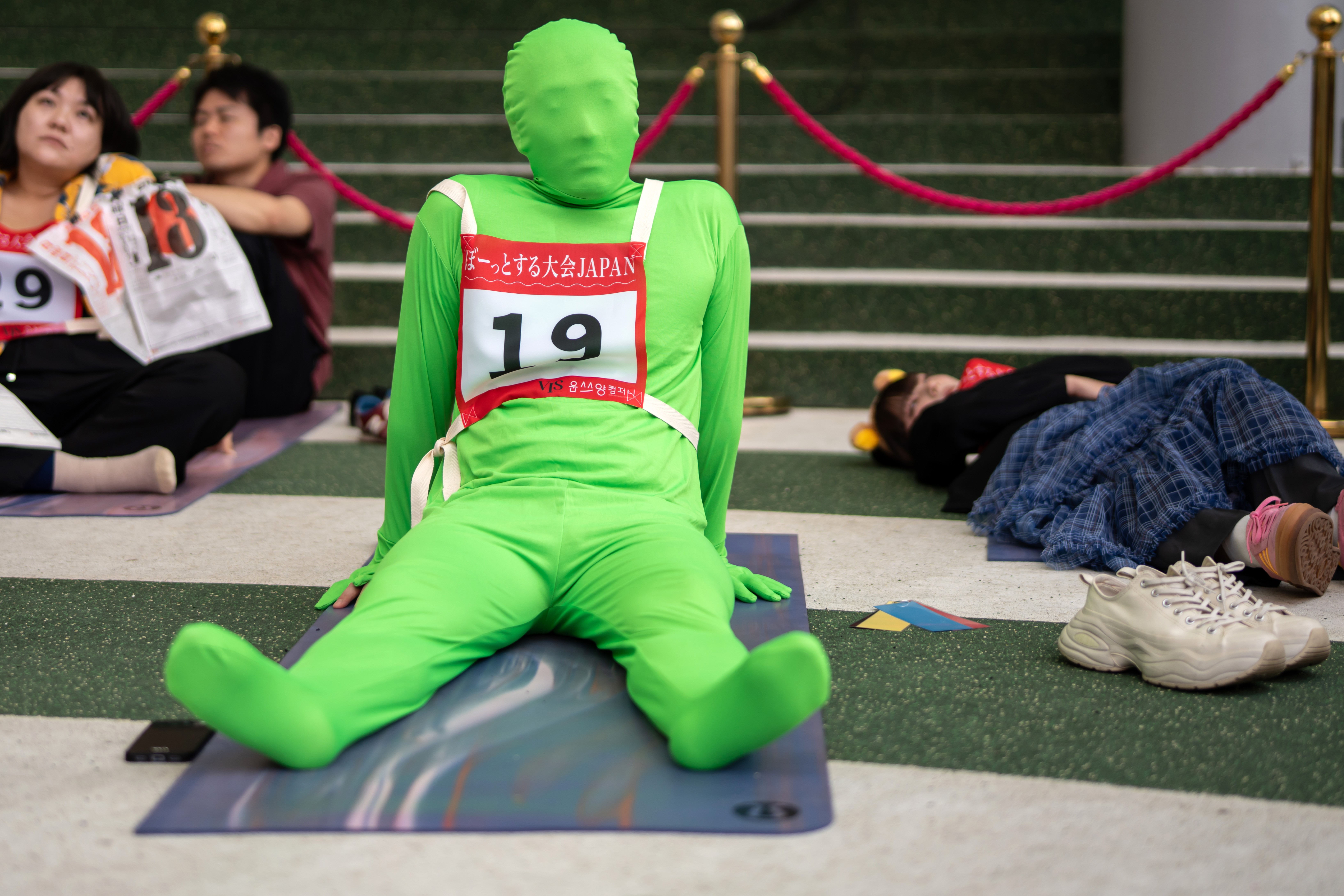 People wearing numbered jerseys lie on the floor during a 
