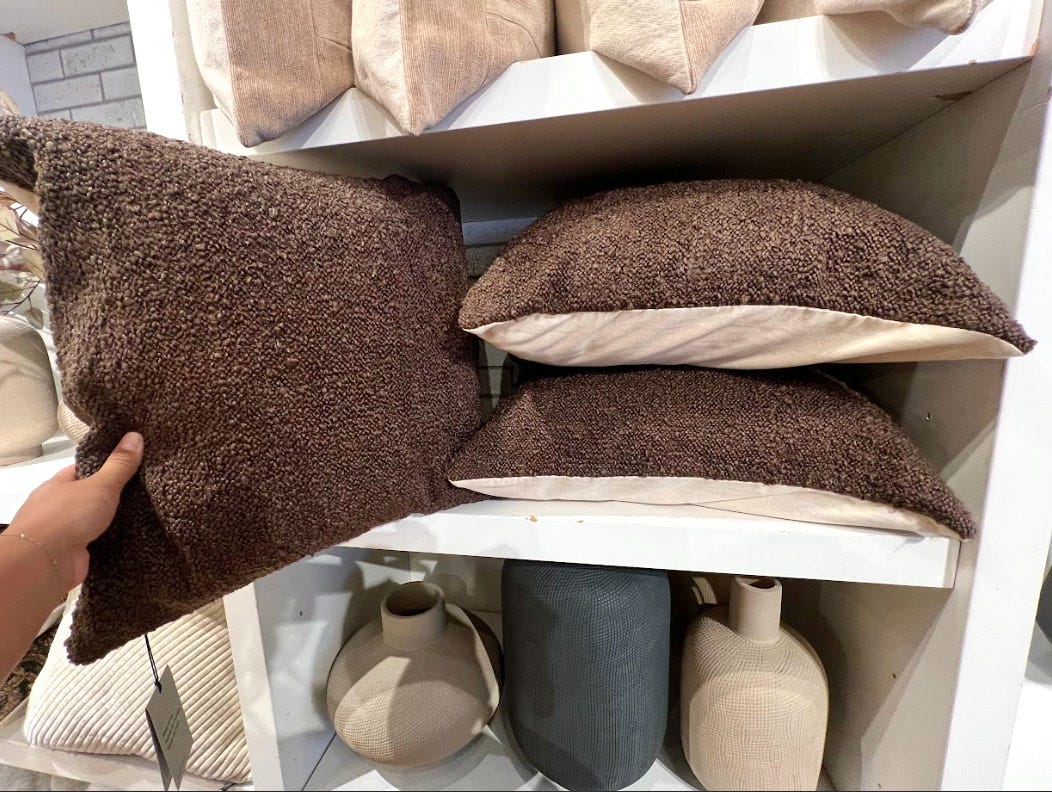 Three brown pillows on a shelf.