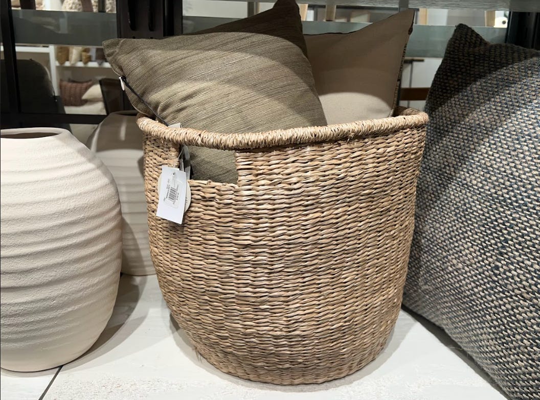 A wicker basket with pillows inside.
