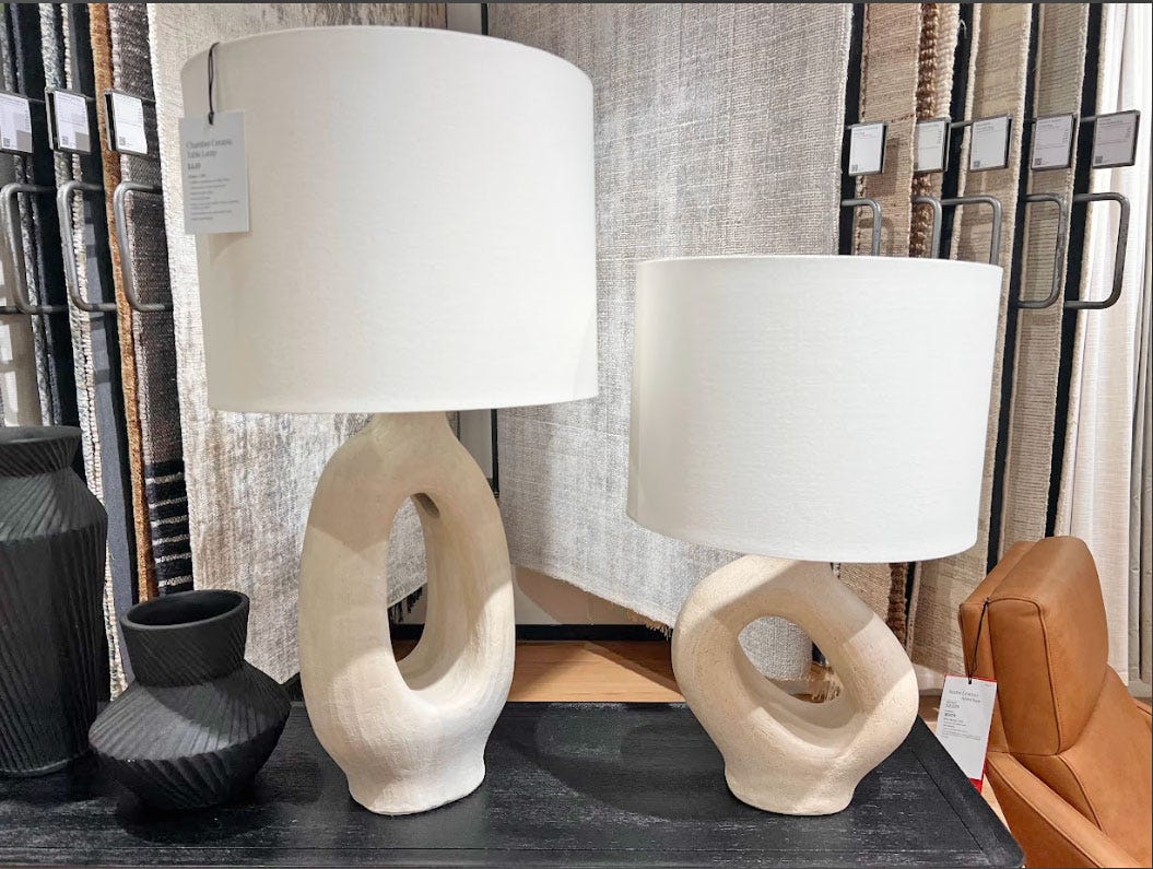 Two lamps in different sizes with white shades and circular bases.