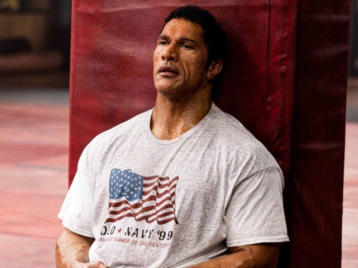 Dwayne Johnson leaning on a railing as Mark Kerr