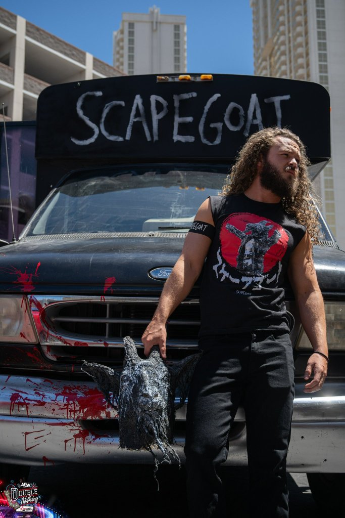 Jack Perry in front of the Scapegoat bus, holding the goat head