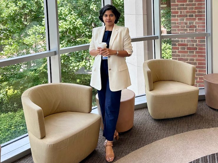 Shreya Mishra Reddy standing in front of a window and holding a coffee cup.