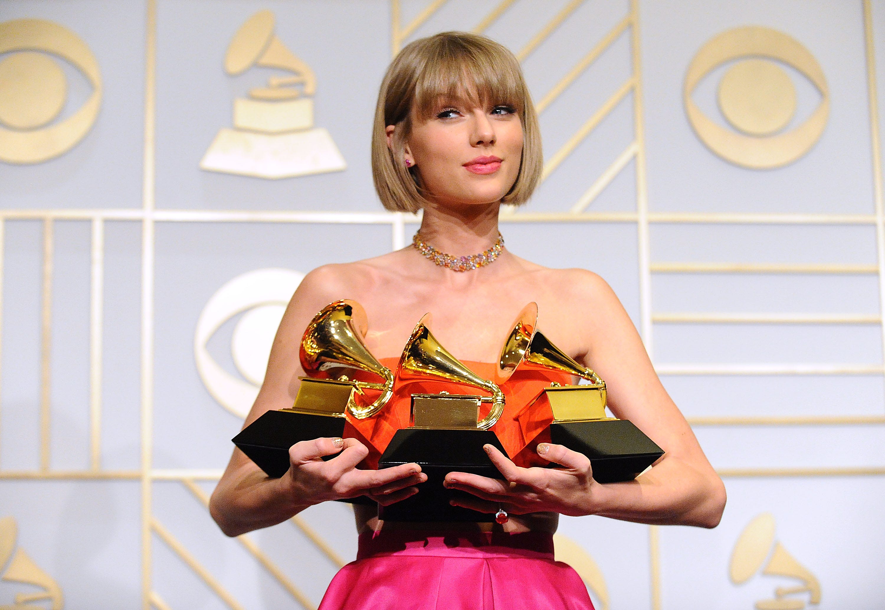 Taylor Swift poses with three awards at the 2016 Grammys.