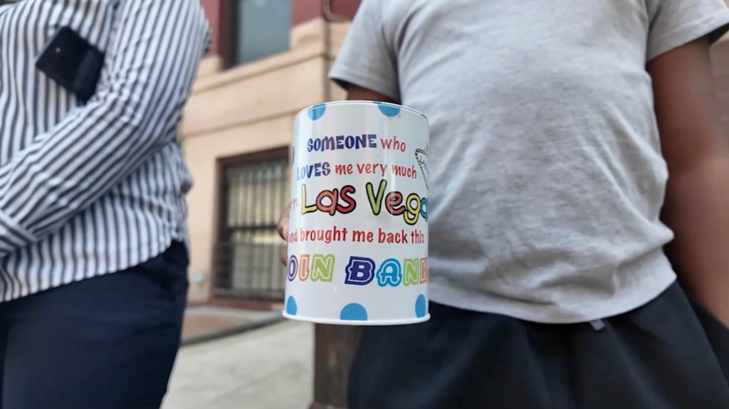 A child holding a Las Vegas coin bank.