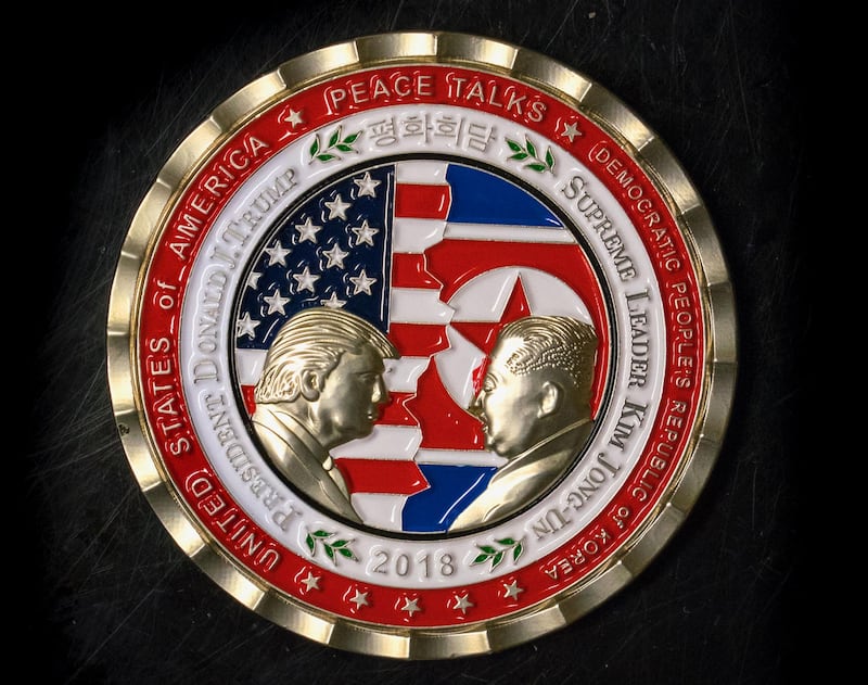 A coin for the upcoming US-North Korea summit is seen in Washington, DC, on May 21, 2018. - A commemorative coin featuring US President Donald Trump and North Korea's Kim Jong Un has been struck by the White House Communications Agency ahead of their summit meeting. The coin depicts Trump and Kim, described as North Korea's 