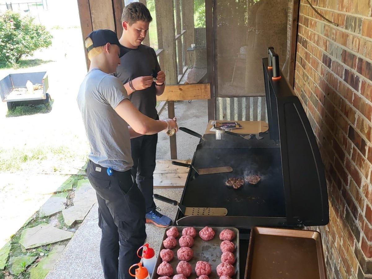 Young men making burgers