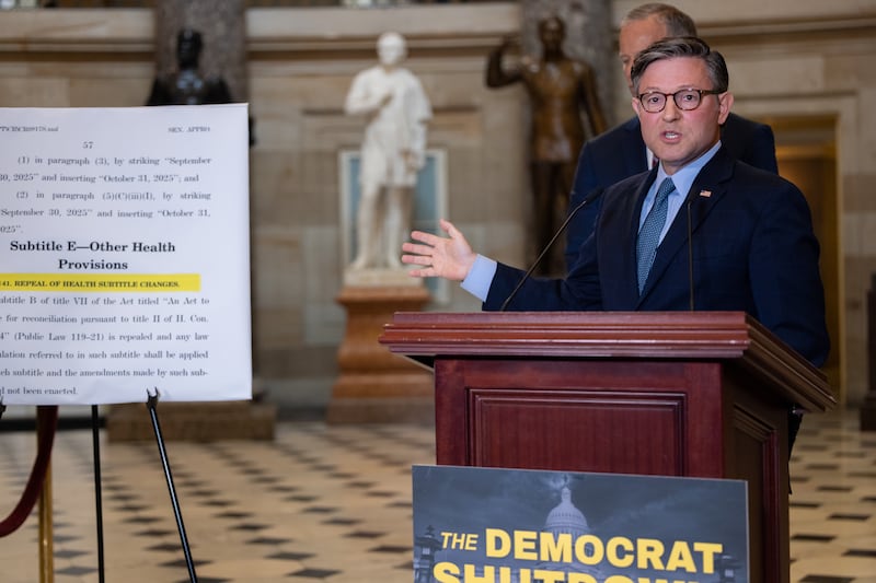 House Speaker Mike Johnson gestures to a poster has he repeats debunked claims Democrats are trying to give undocumented immigrants health care coverage as the government shutdown continues for a third day.