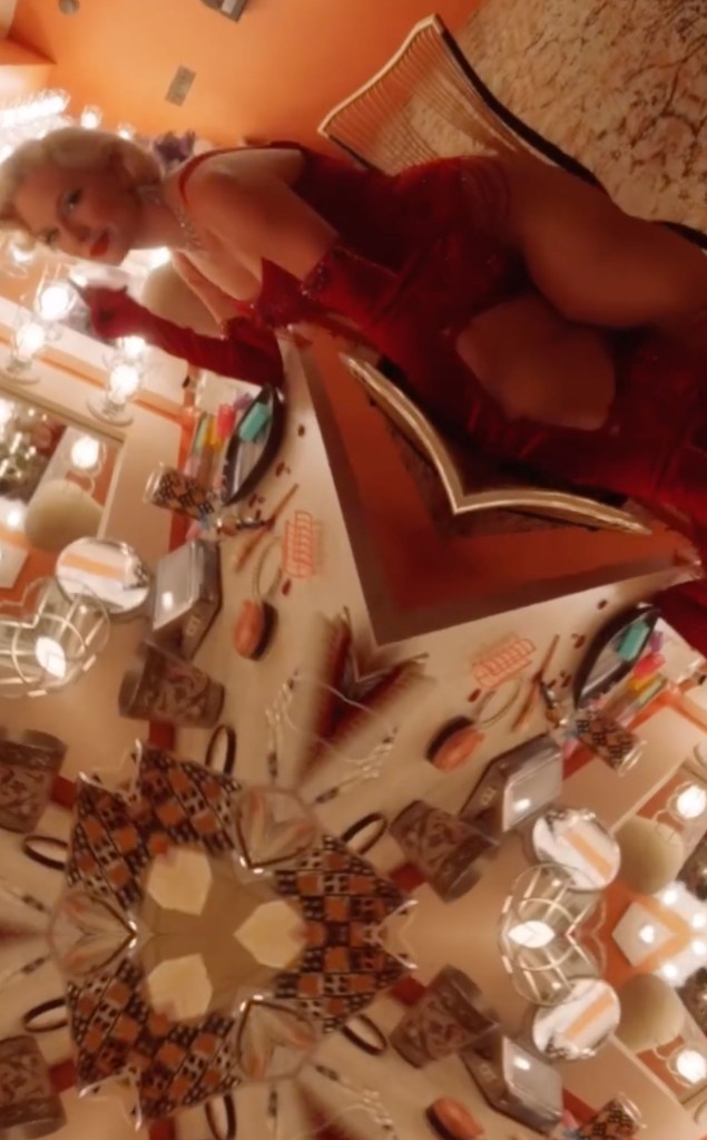Taylor Swift in a red dress with gloves, appearing as Marilyn Monroe, within a kaleidoscope-like pattern.