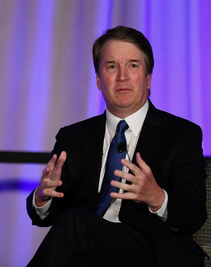 Justice Brett Kavanaugh speaking at a panel, gesturing with his hands.