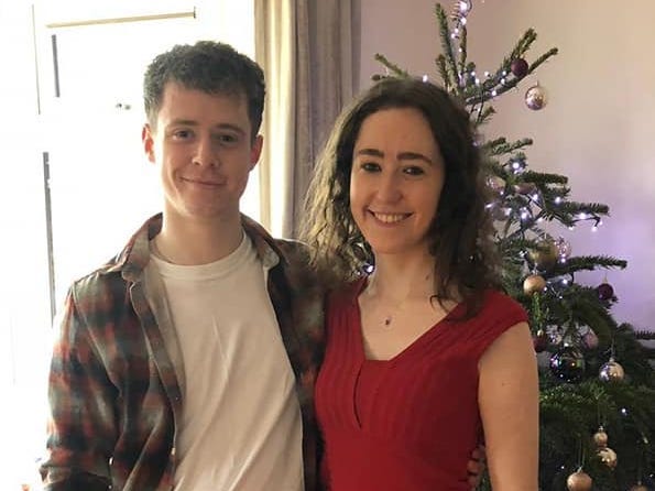 A couple standing in front of a Christmas tree