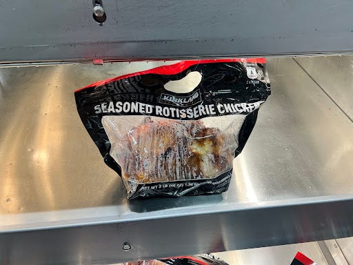 Bag of Costco rotisserie chicken on metal shelf in