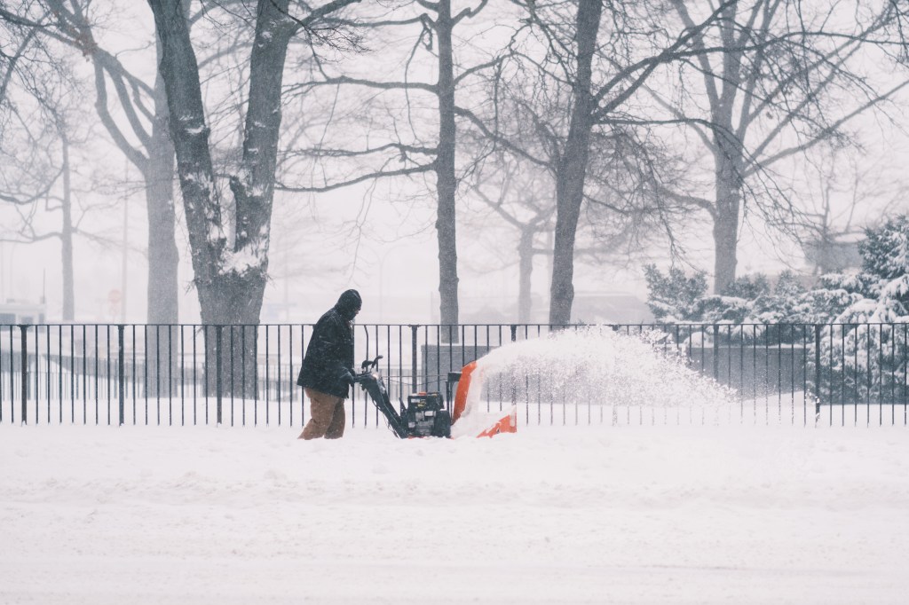 Man clears a sidewalk on Queens Blvd using a snowblower during a snowstorm on Jan. 29, 2022