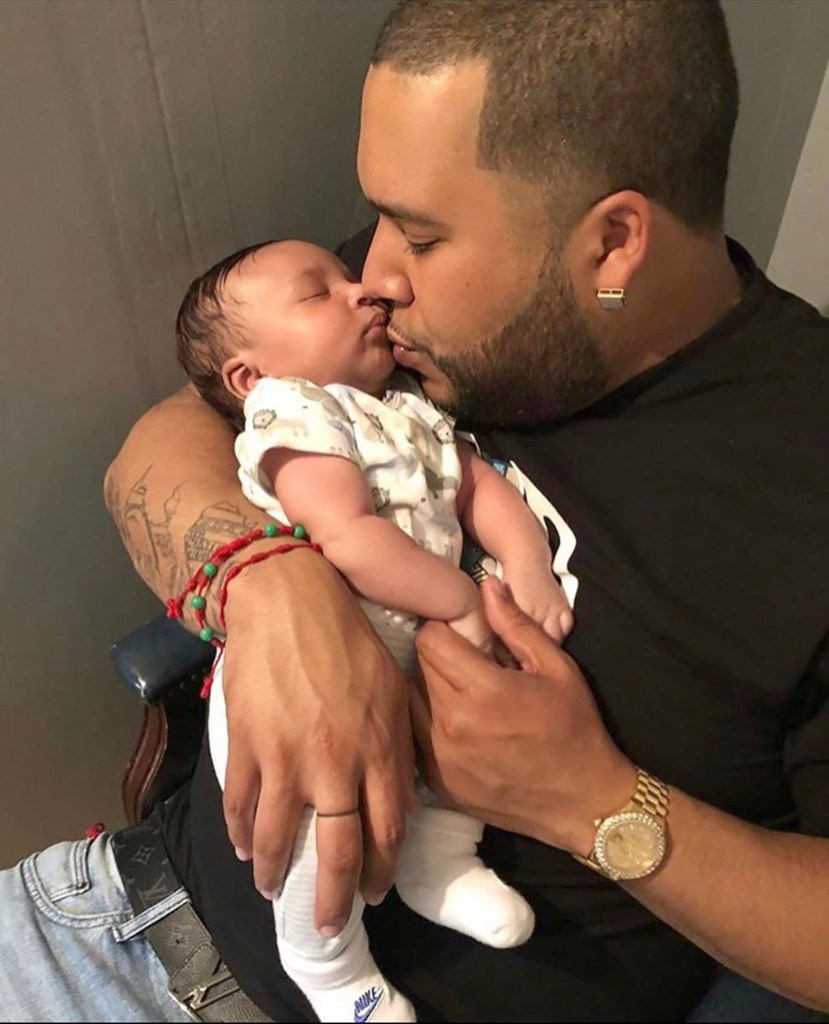 Allan Feliz, 31, holding and kissing his 5-month-old son Eli James.
