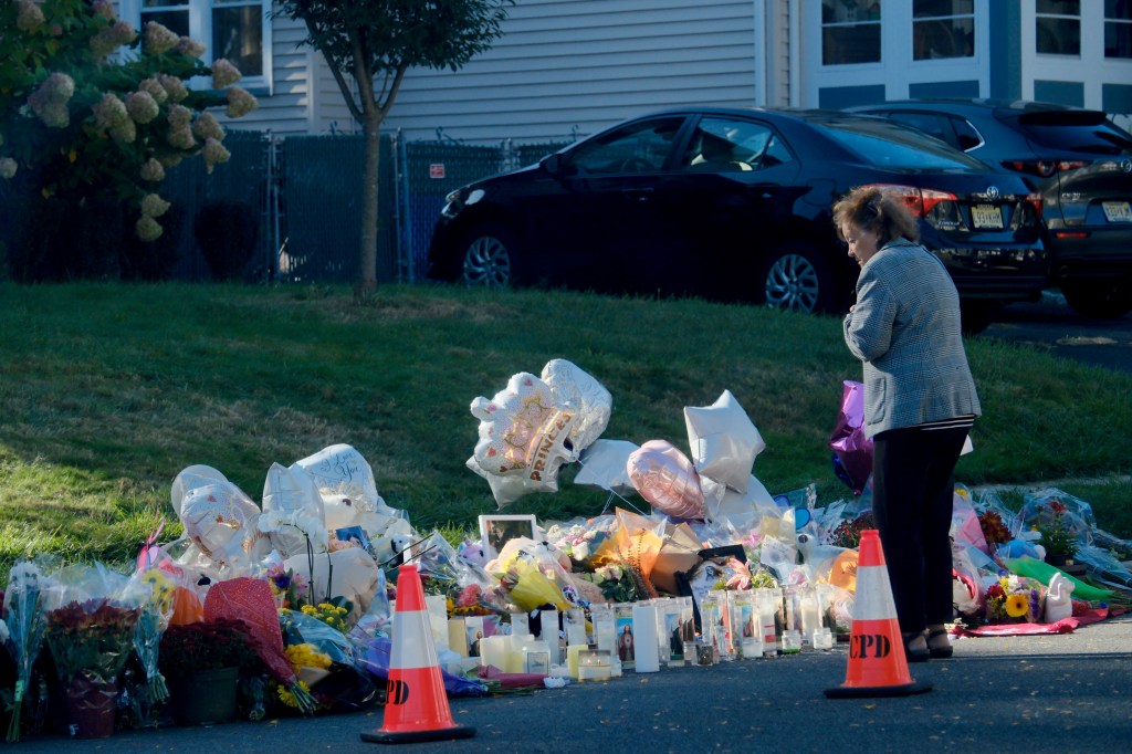woman visits candle, flower laden memorial for slain teens
