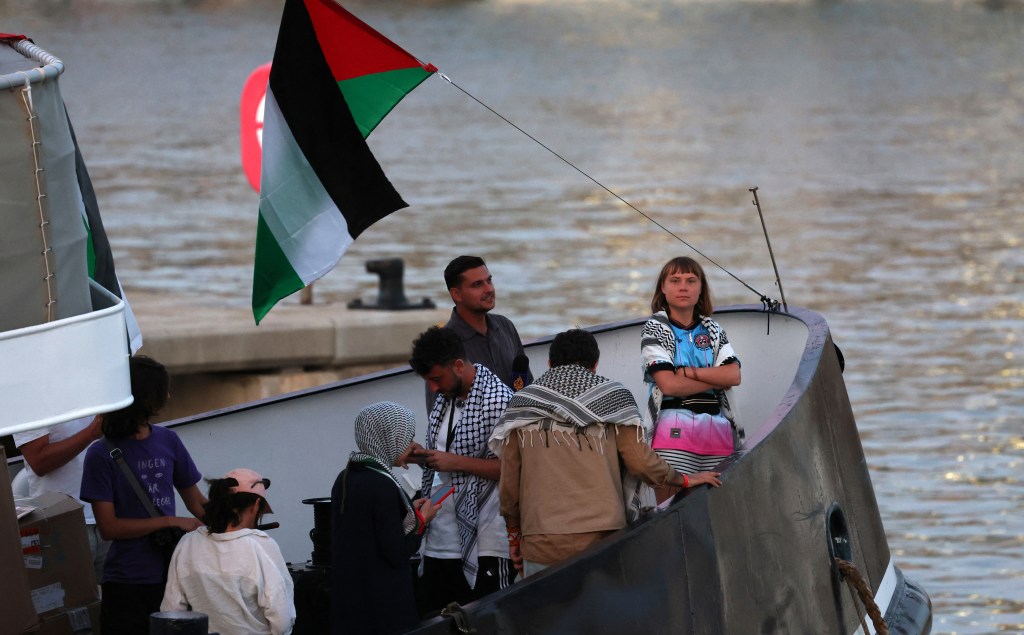 Greta Thunberg and other activists on a flotilla with a Palestinian flag.