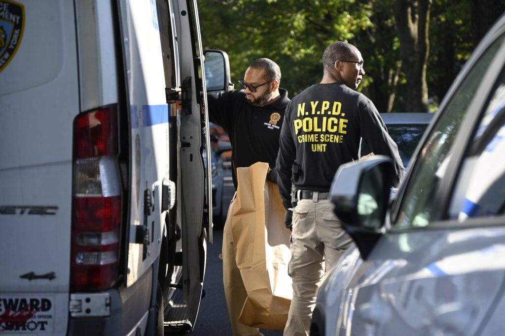 NYPD Crime Scene Unit investigators removing evidence bags from a white van.