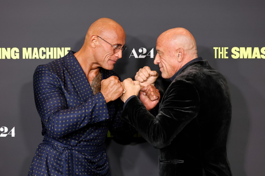 Dwayne “The Rock” Johnson (left) and MMA legend Mark Coleman square off to see who will be first to enter the LA premiere of Johnson’s film, “The Smashing Machine.”
