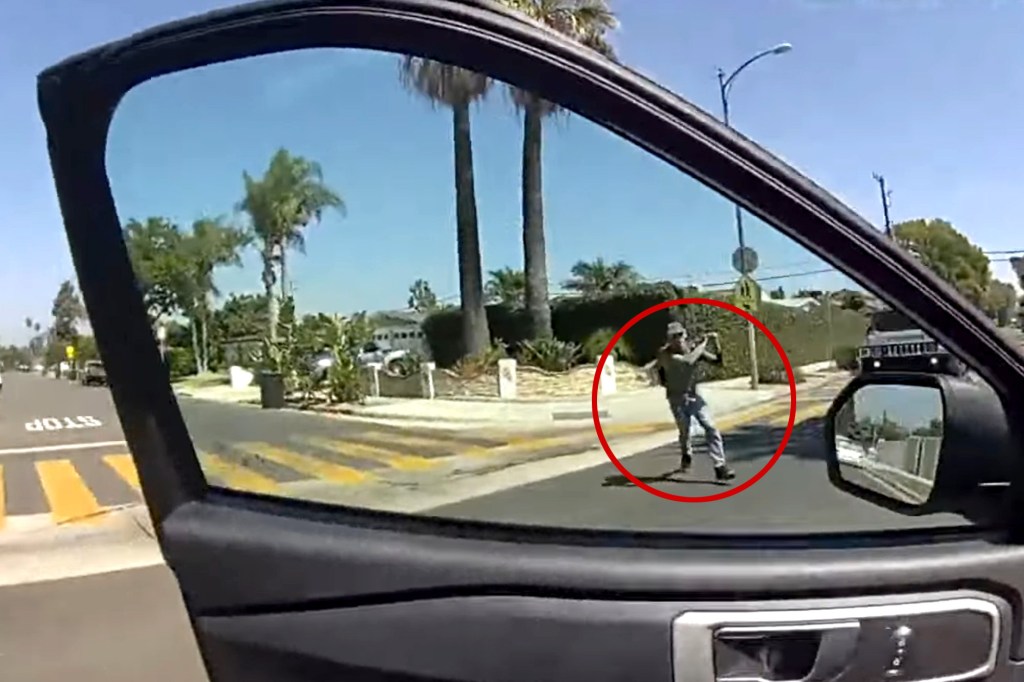 Rudy Anthony Martinez II holding a shovel, as seen through a car window.