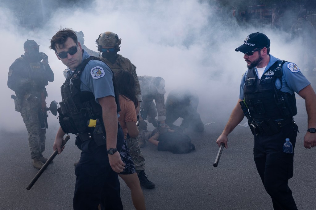 Chicago police officers reacting to tear gas used by federal law enforcement during a confrontation with activists.