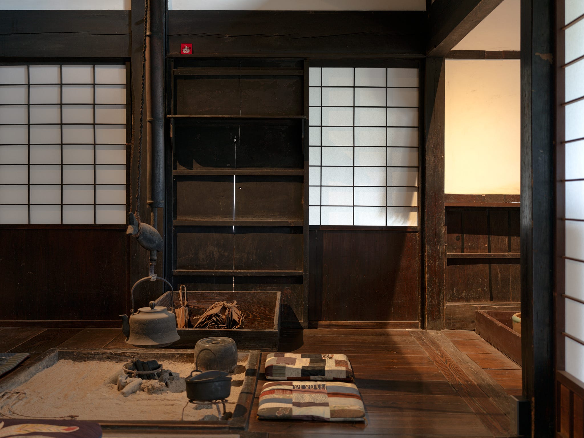 A close-up of an irori, a traditional Japanese sunken hearth fired with charcoal, in the house.