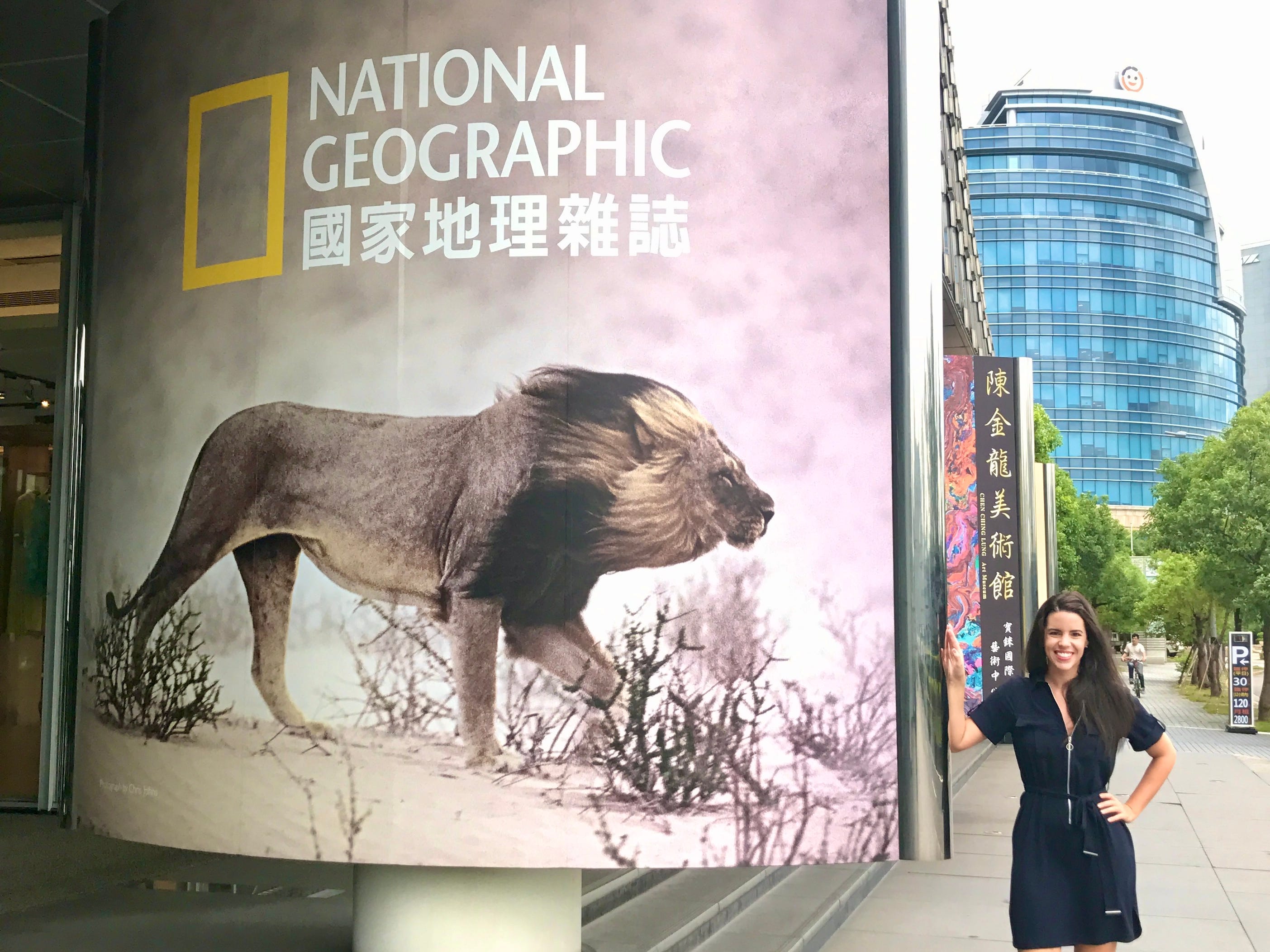 Alaina Appleman is posing next to a National Geographic signboard.