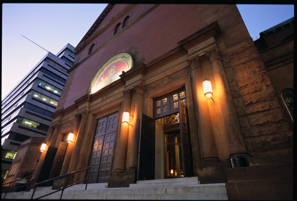 The facade of the Cathedral of St. Matthew the Apostle in Washington, DC with its large doors open.