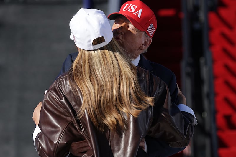 NORFOLK, VIRGINIA - OCTOBER 05: First Lady Melania Trump and U.S. President Donald Trump embrace as he takes the stage to make remarks during the Navy 250 Celebration aboard the USS Harry S. Truman aircraft carrier on October 5, 2025 in Norfolk, Virginia. President Trump is visiting Naval Station Norfolk in Virginia for a celebration of the 250th birthday of the U.S. Navy. (Photo by Alex Wong/Getty Images)