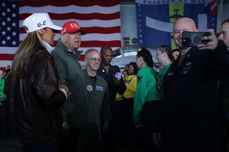 First Lady Melania Trump and U.S. President Donald Trump speak with people aboard the USS George H.W. Bush aircraft carrier after observing naval flight demonstrations on October 5, 2025 off the eastern coast of the United States. President Trump is visiting Naval Station Norfolk in Virginia for a celebration of the 250th birthday of the U.S. Navy. Photo by Alex Wong/Getty Images)