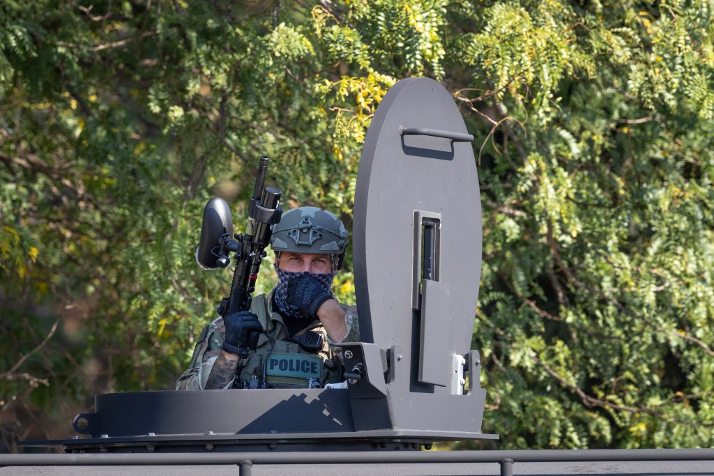A federal law enforcement agent with a paintball gun in a turret.