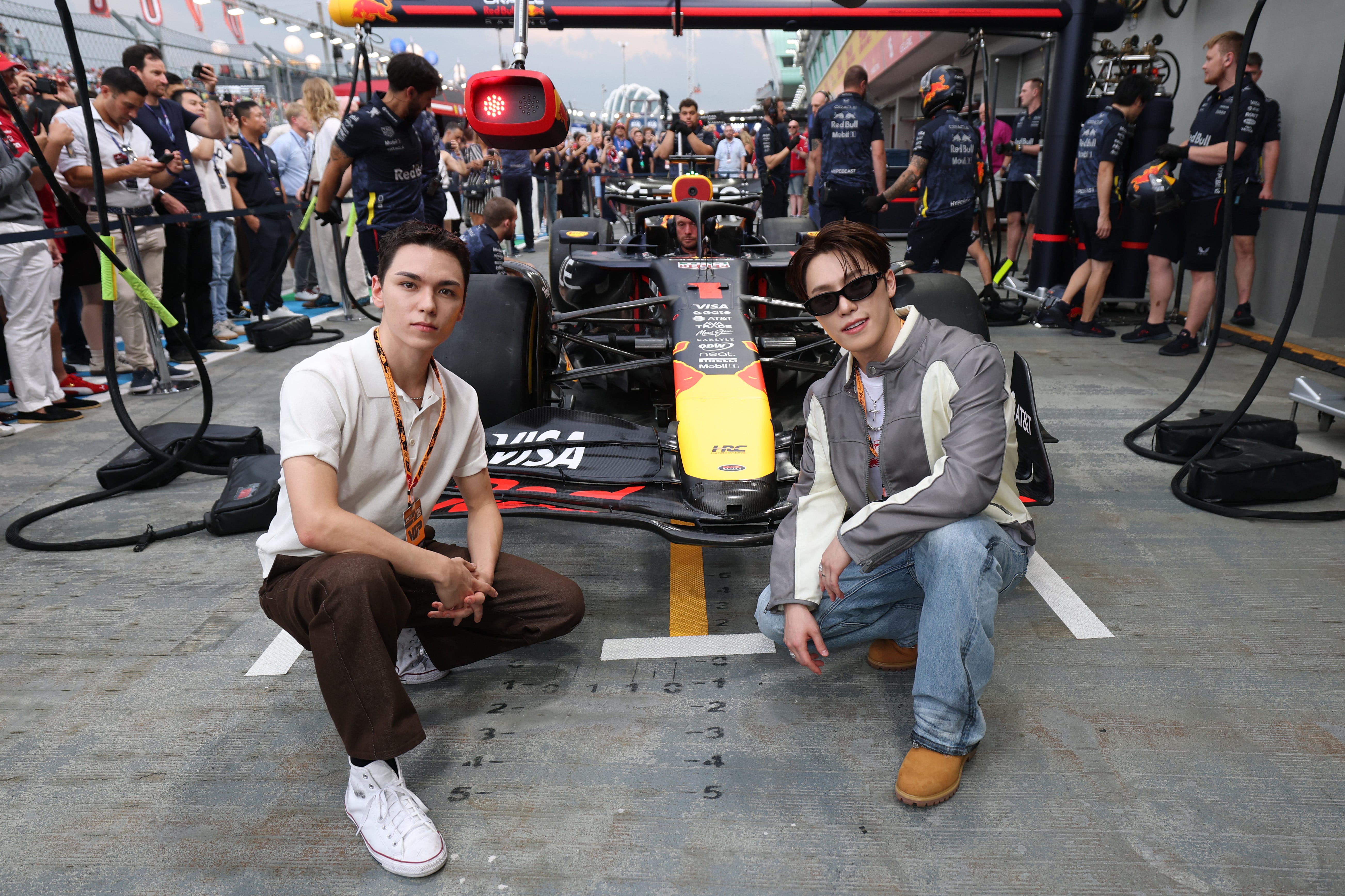 Vernon and Dino of Seventeen in the Pitlane with the car of Max Verstappen of the Netherlands and Oracle Red Bull Racing prior to the F1 Grand Prix of Singapore at Marina Bay Street Circuit on October 05, 2025 in Singapore, Singapore.
