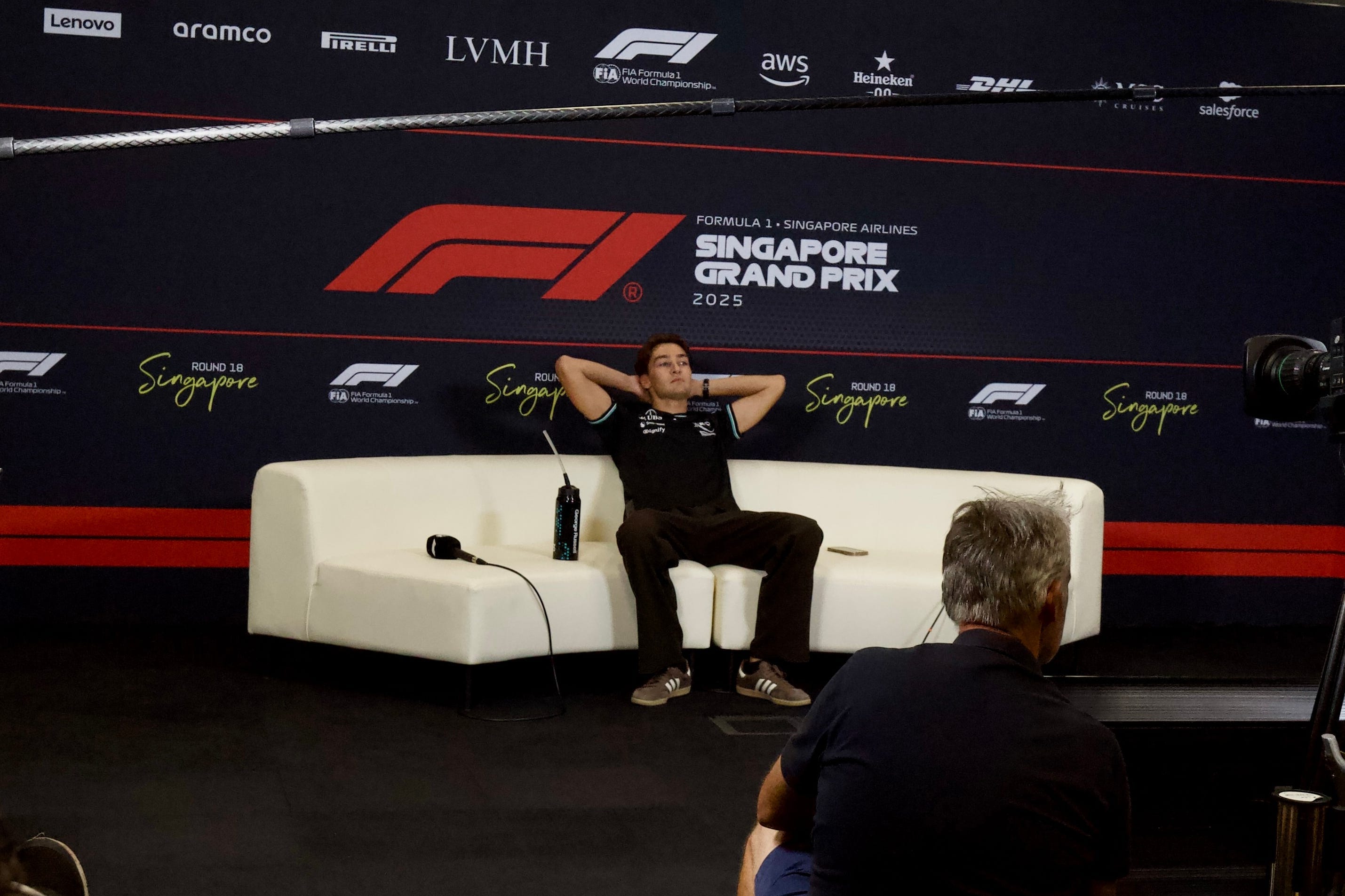 George Russell of Mercedes enjoying the cool of a press conference room after his big win.