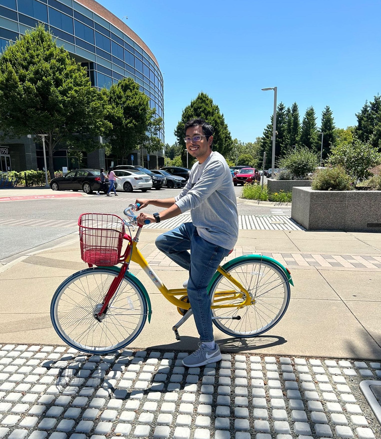 Goutam Nair rides a red, yellow, and green bike