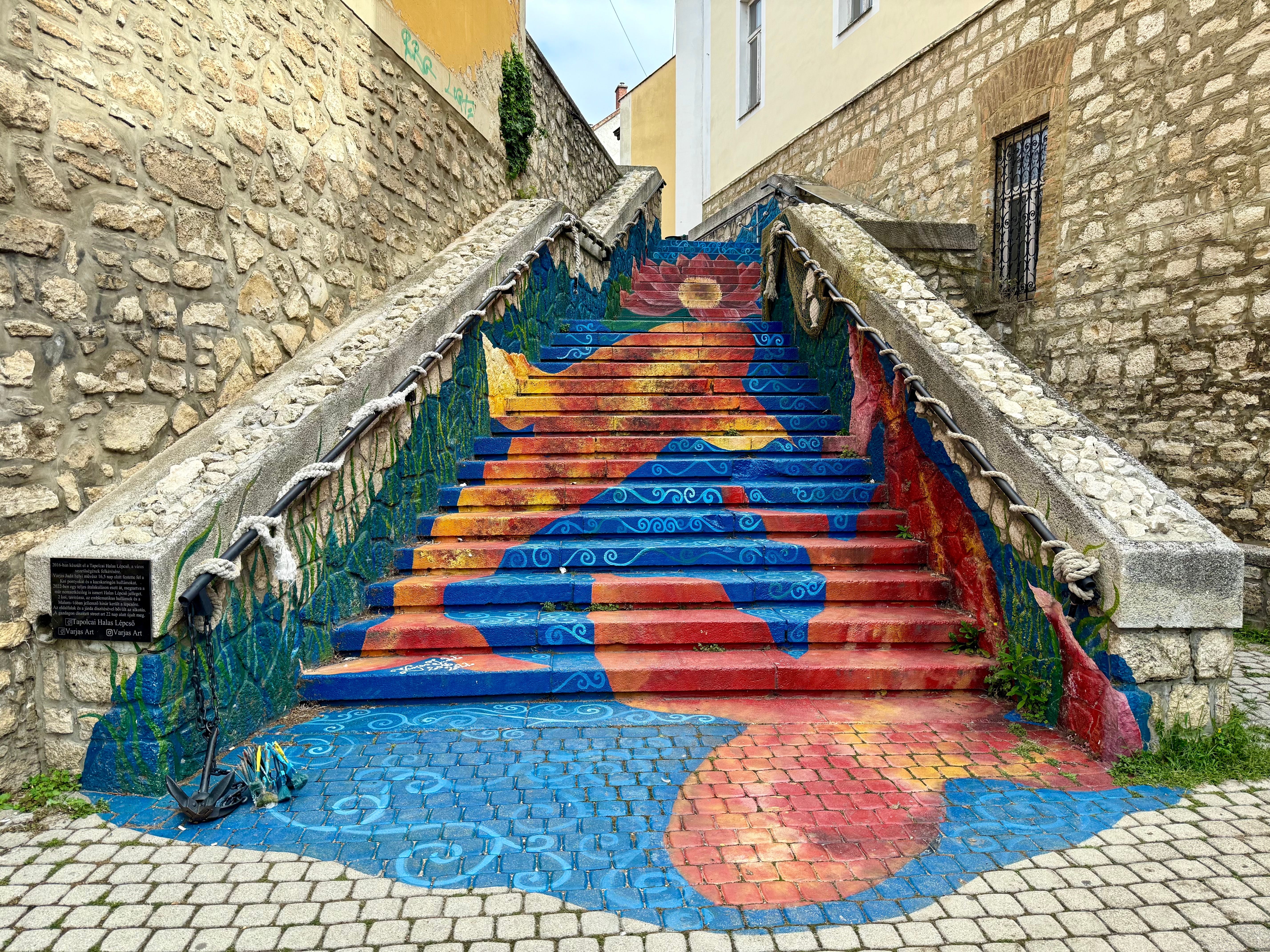 A staircase in Tapolca, Hungary, painted to show water, flowers, and koi fish.