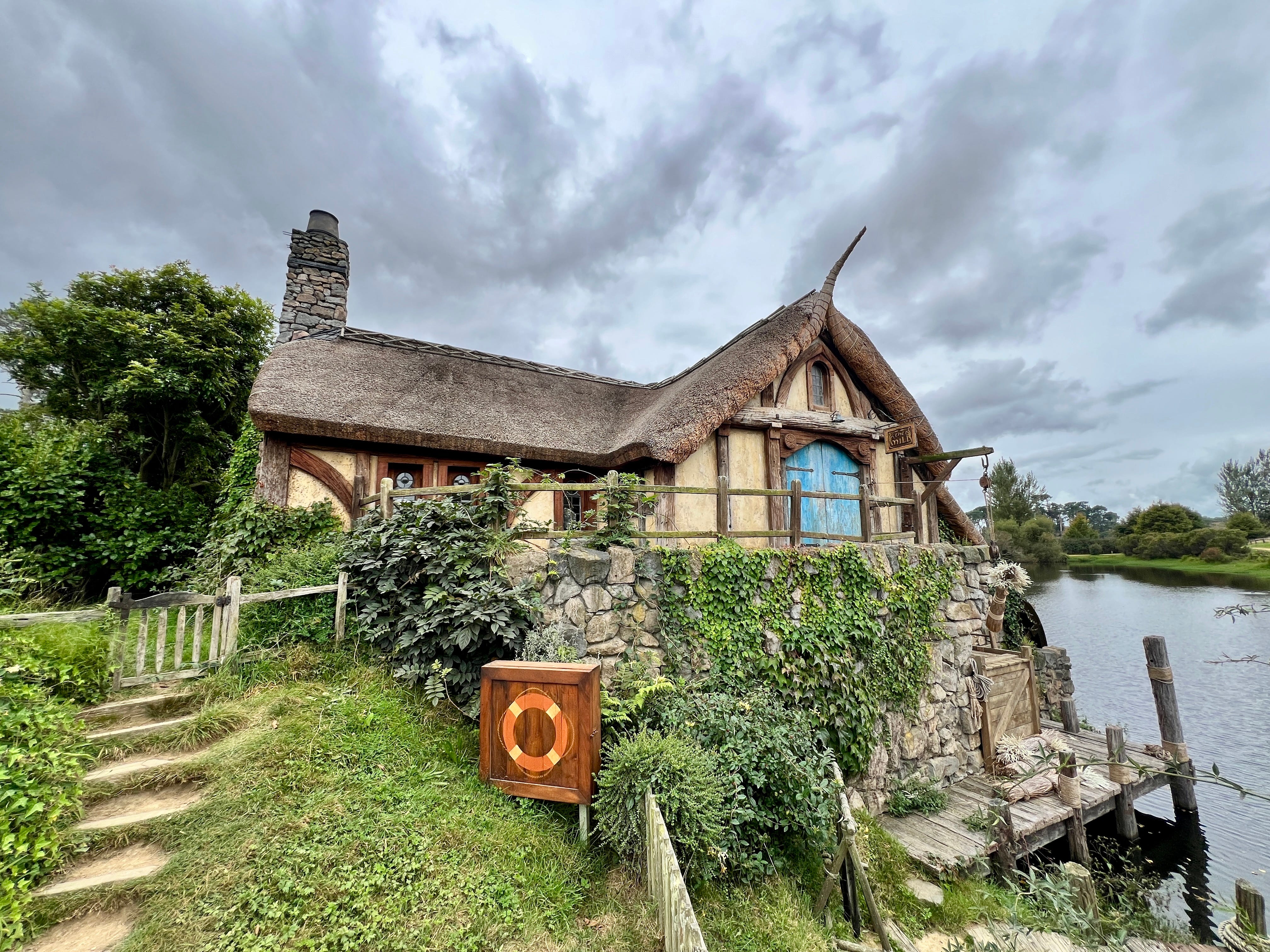 Hobbit house surrounded by greenery, water