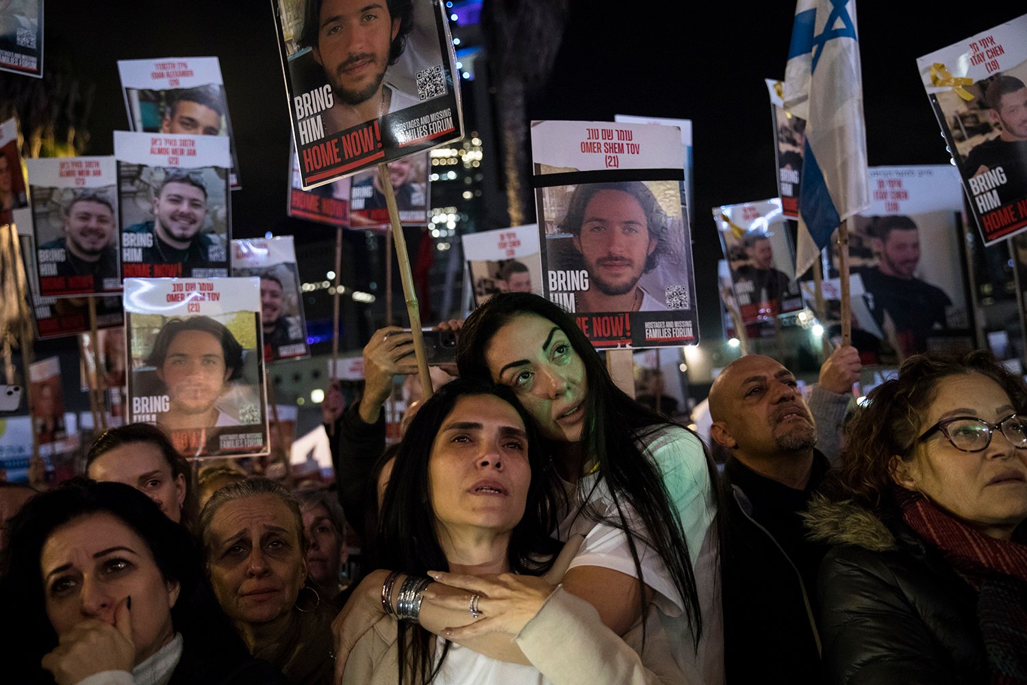 People stand while holding signs.