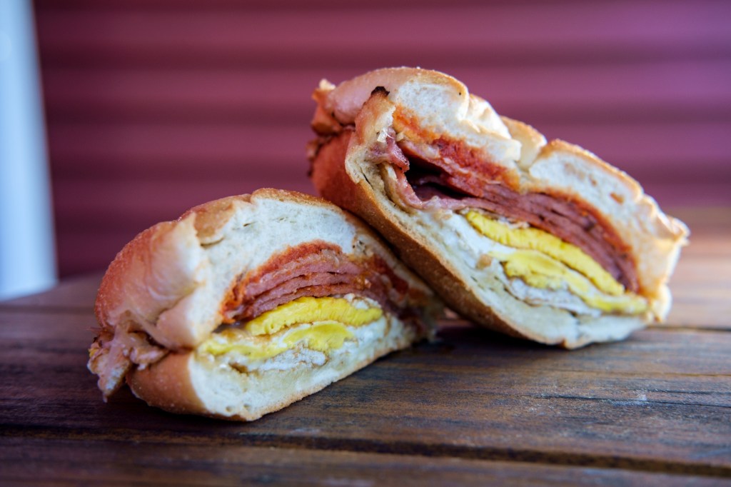 Taylor ham, pork roll, egg, and cheese breakfast sandwich on a kaiser roll.