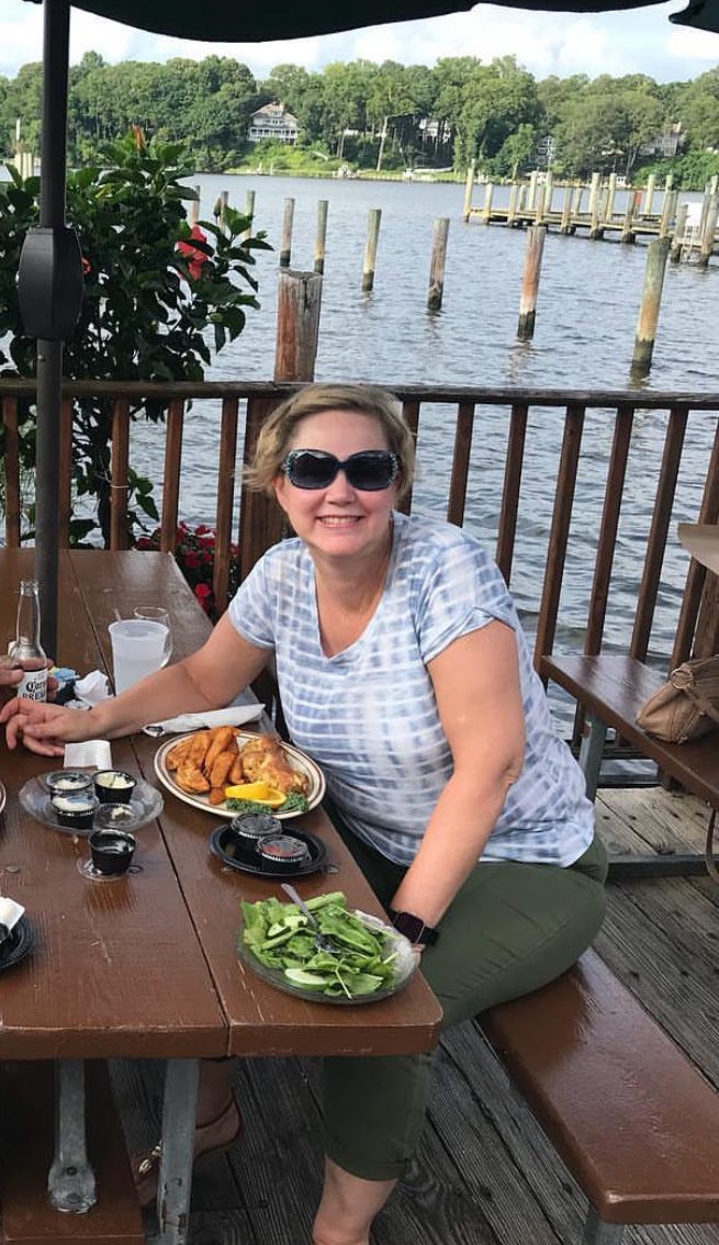 The author poses while dining outdoors waterside in 2018.