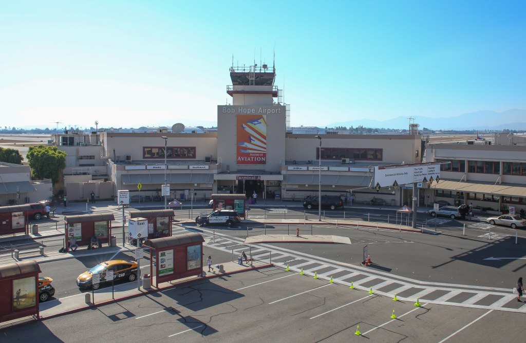 Bob Hope Airport terminal building with a control tower on top, airport taxi stands, and drop-off/pick-up lanes.