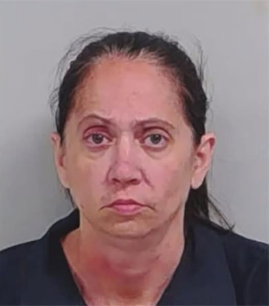 Mugshot of a woman with dark hair pulled back, wearing a dark shirt.